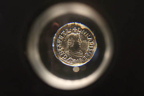 A friendly club member examining a rare coin under a magnifying glass.