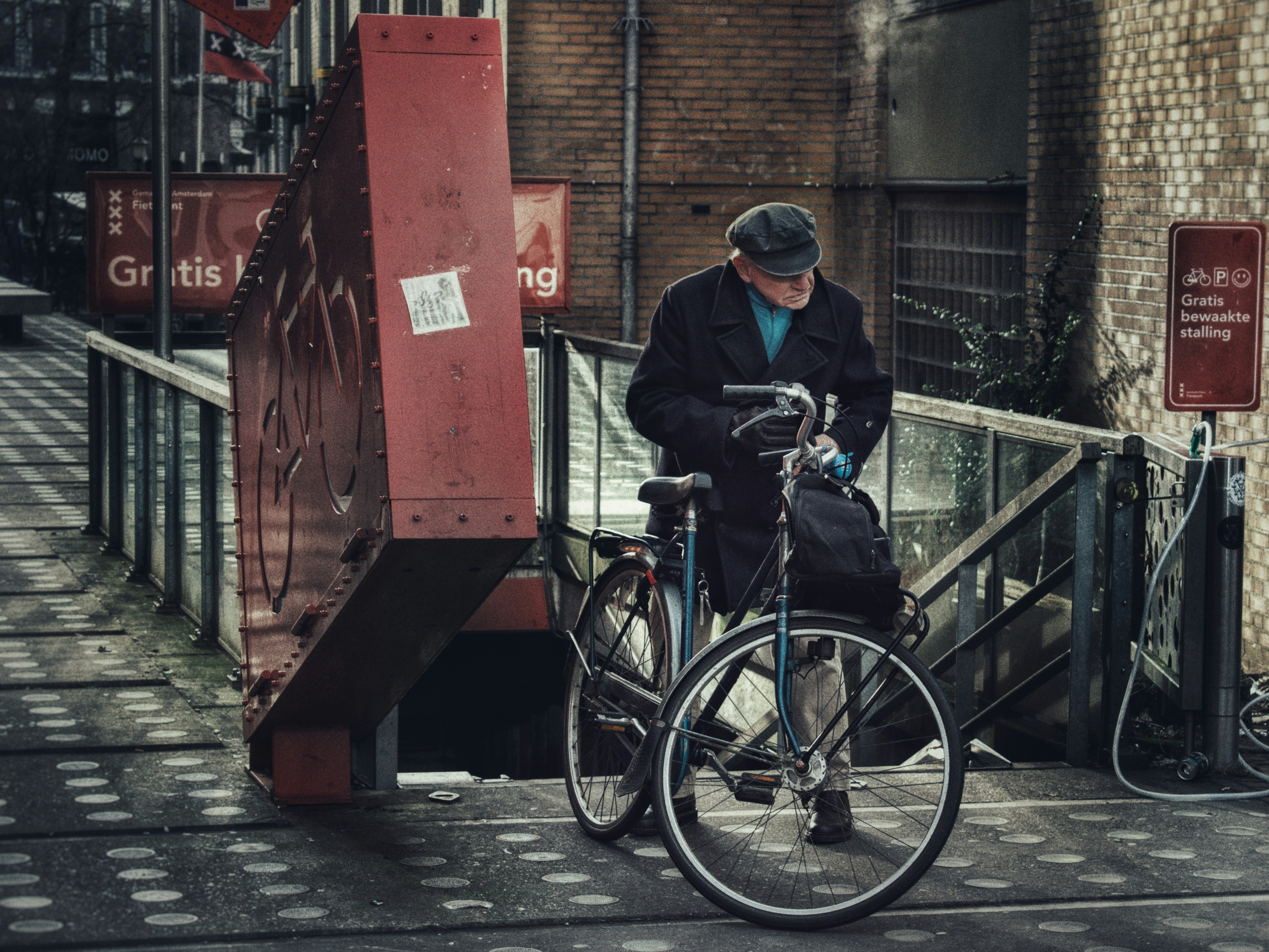 Ein Mann steht neben einem Fahrrad auf einem Bürgersteig