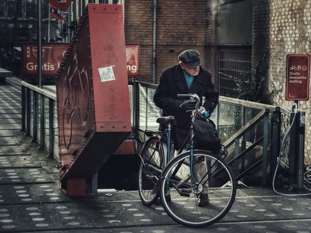 a man standing next to a bike on a sidewalk