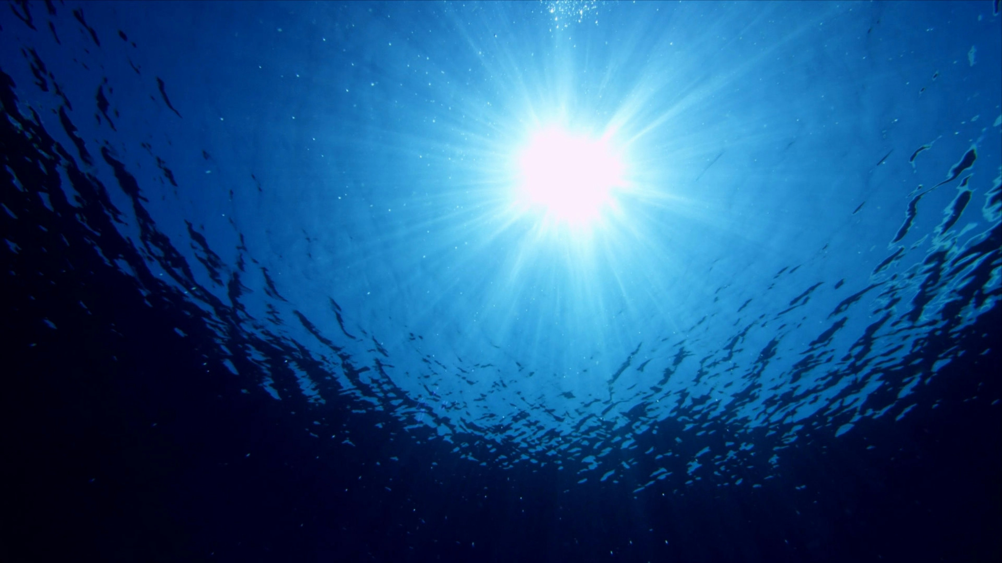 the sun shines brightly in the blue water