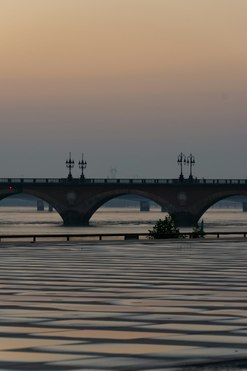 a bridge over a body of water at sunset