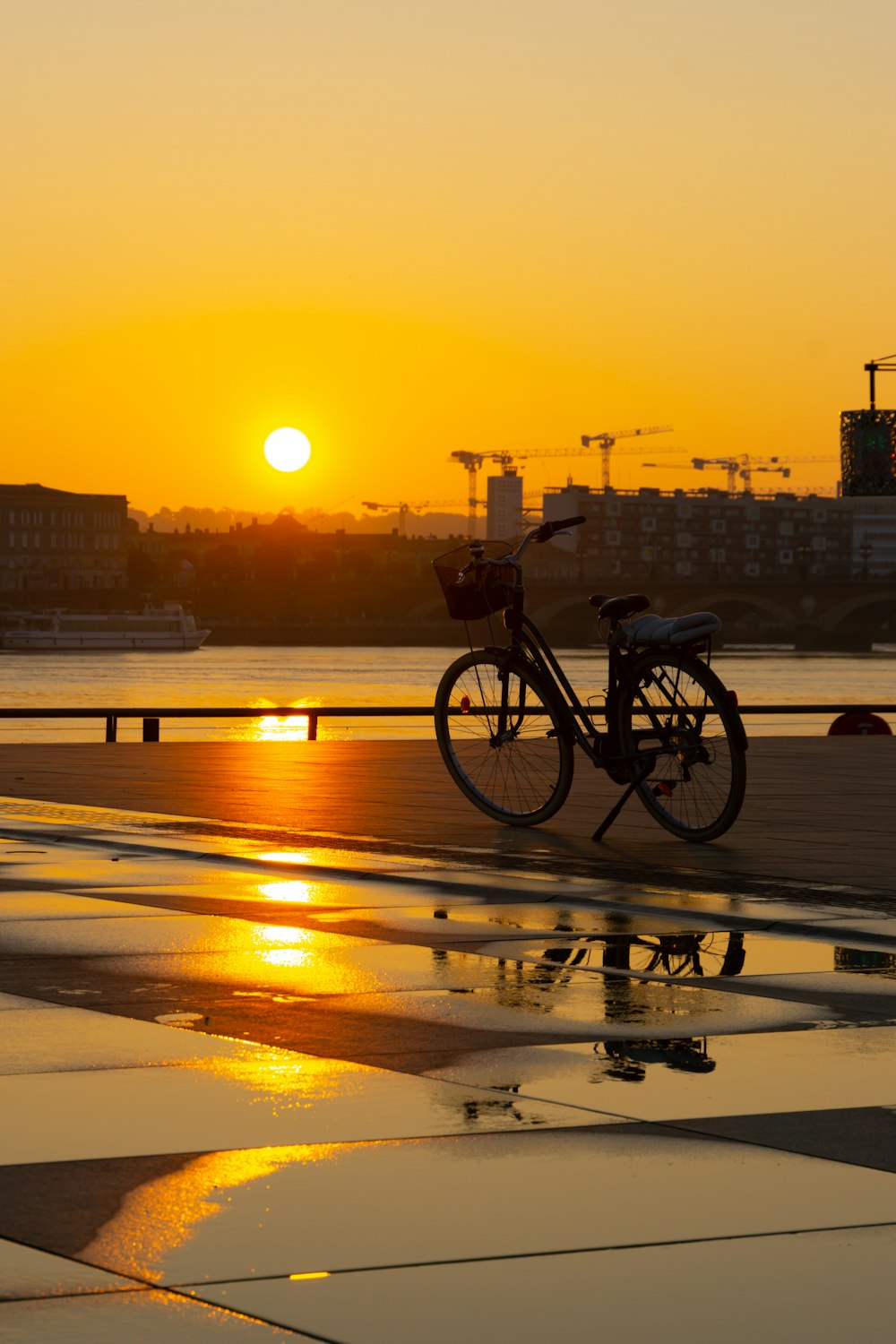 a bike parked next to a puddle of water