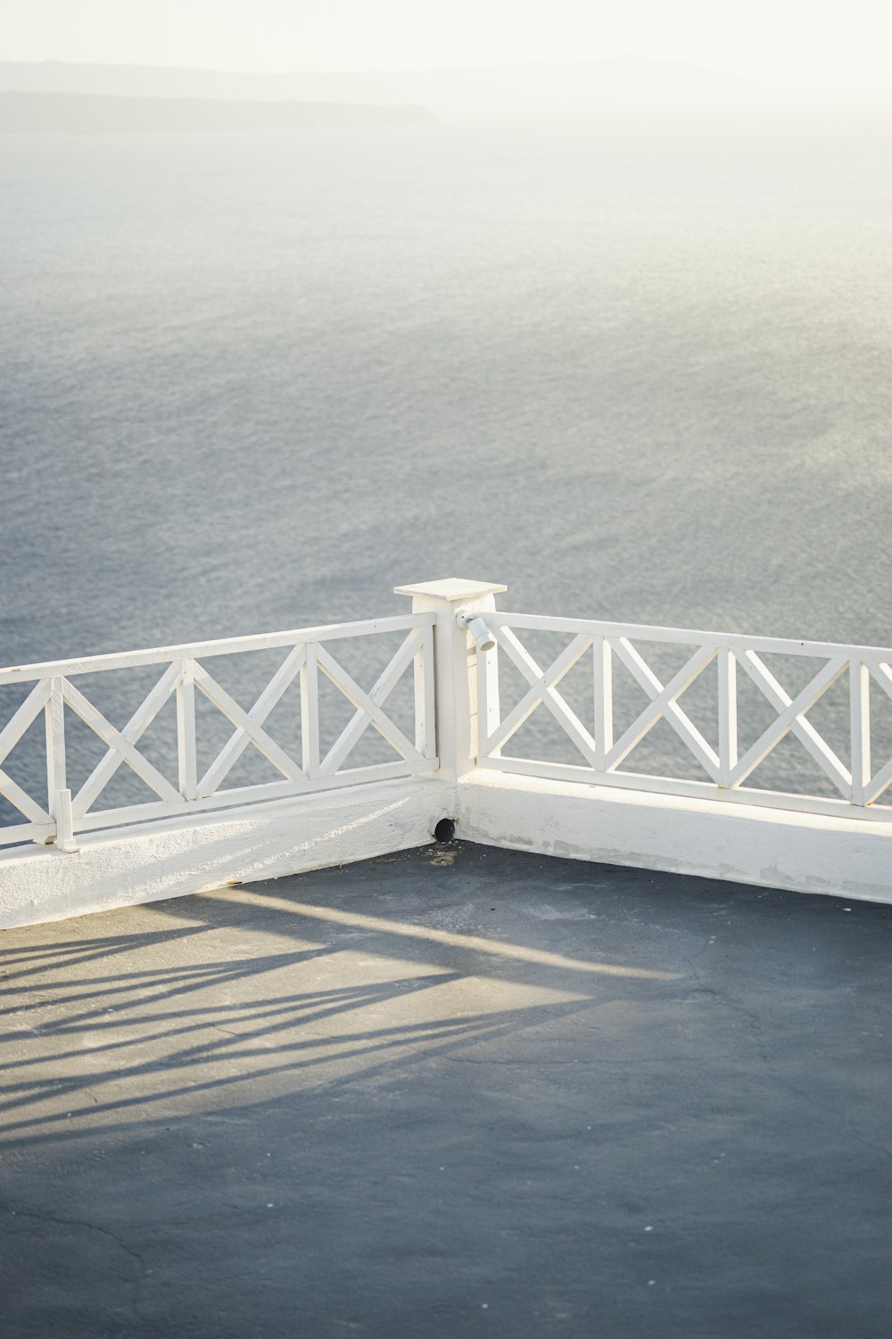 a man sitting on top of a white bench next to the ocean