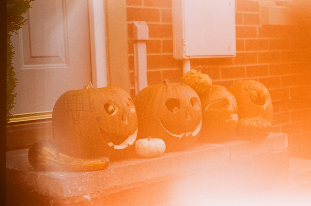 a group of carved pumpkins sitting on a porch
