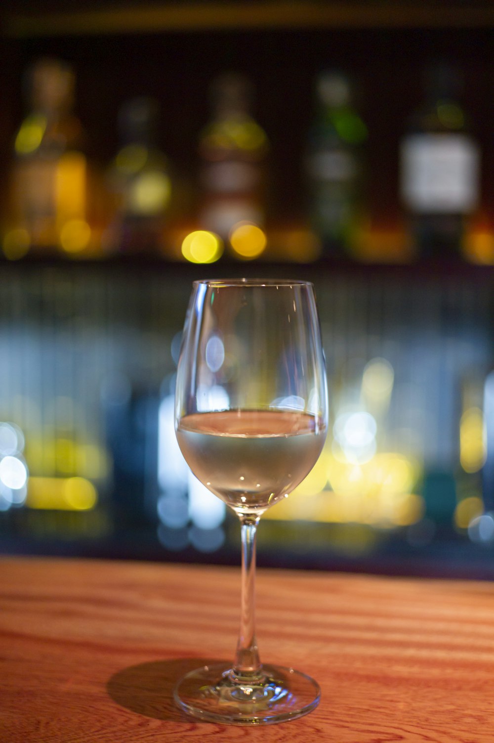 a glass of wine sitting on top of a wooden table