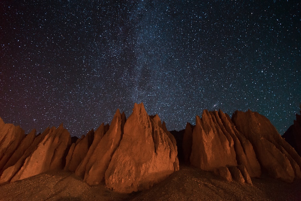 the night sky is filled with stars above a mountain range