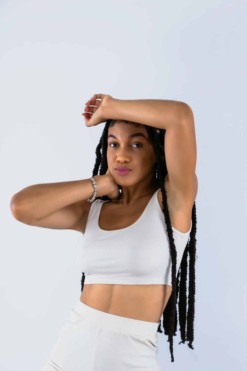 a woman wearing a white crop top and white shorts