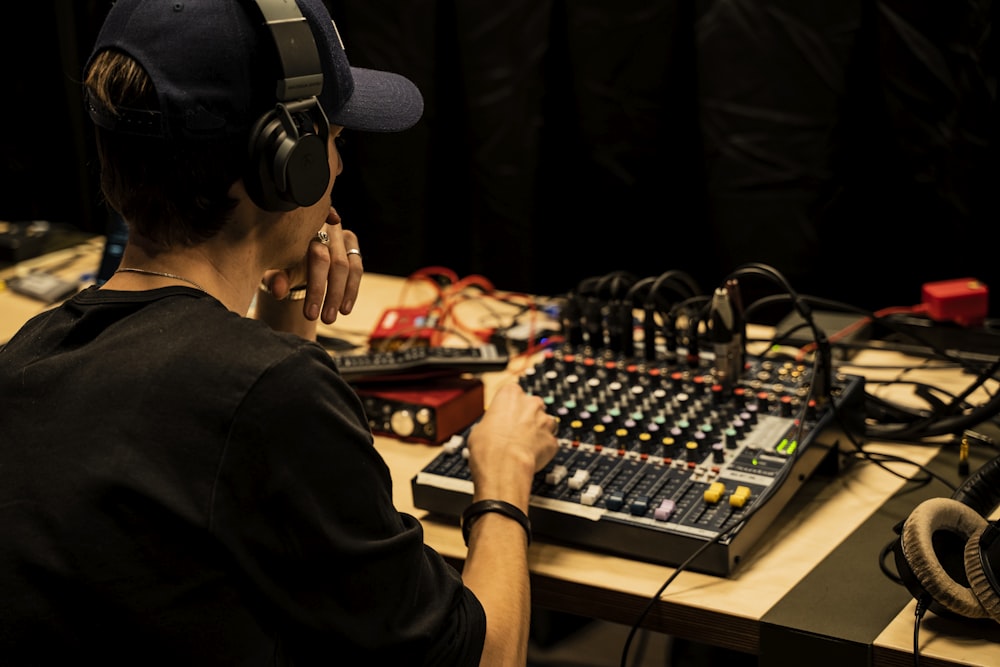 a man sitting in front of a mixing desk with headphones on