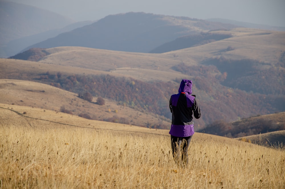a person in a field with mountains in the background