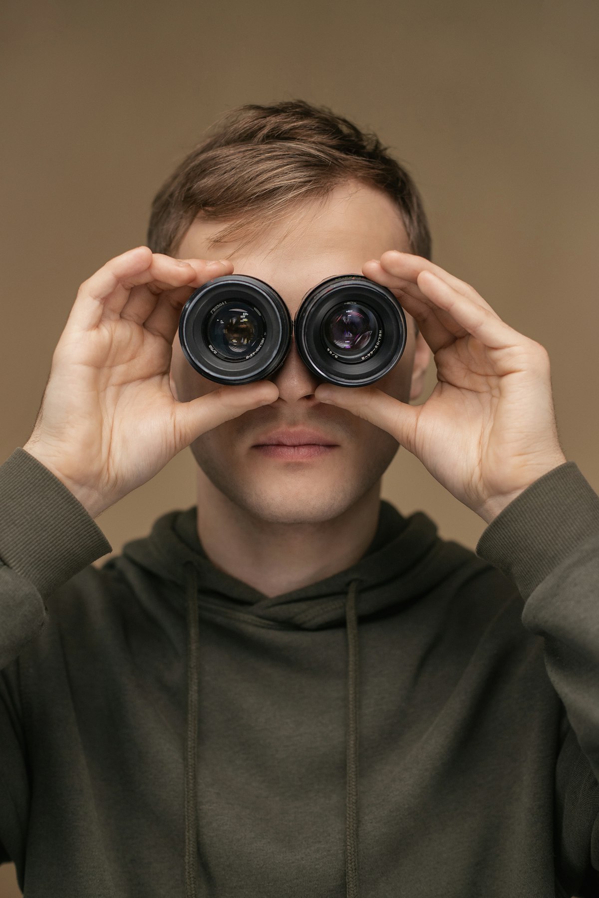 A person looking through binoculars, representing the practice of watching what a competitor's customers say in public
