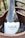 A bottle of wine labeled 'MAÍA BENACUS' rests in a wooden ice bucket. The bottle's design features a constellation pattern over a night sky background. The text 'GARDA DOC' is displayed on the neck of the bottle.