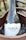 A bottle of wine labeled 'MAÍA BENACUS' rests in a wooden ice bucket. The bottle's design features a constellation pattern over a night sky background. The text 'GARDA DOC' is displayed on the neck of the bottle.