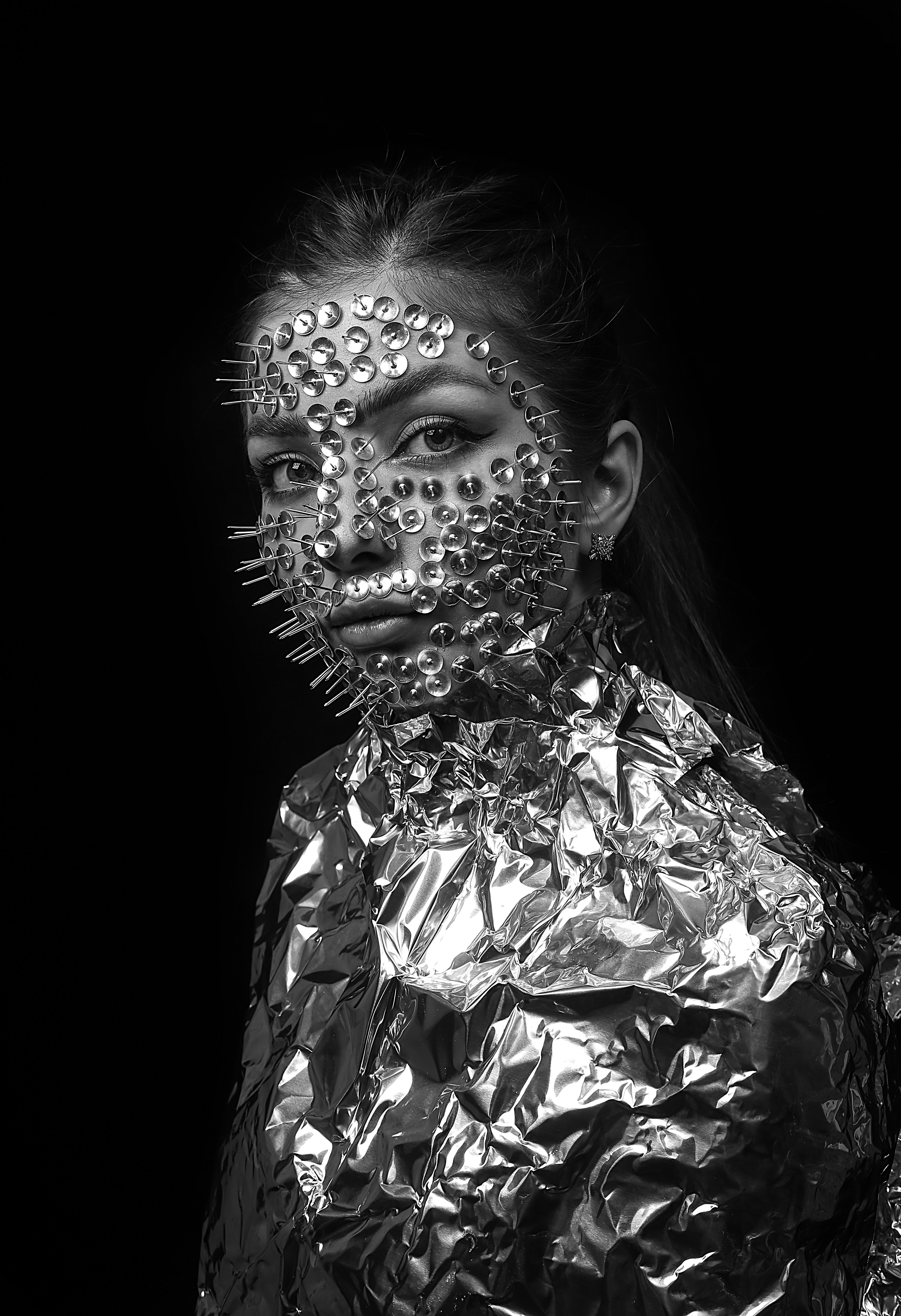 顔にスパイクが付いたメタリックジャケットを着た女性