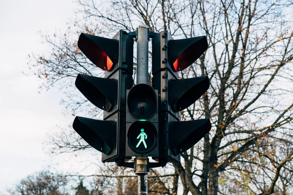 a traffic light with a green pedestrian sign on it