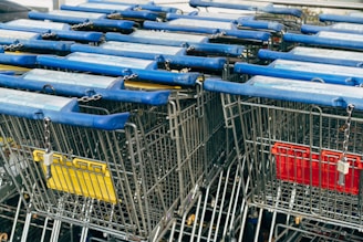 a row of shopping carts with blue and yellow handles