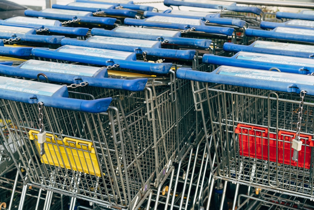 a row of shopping carts with blue and yellow handles