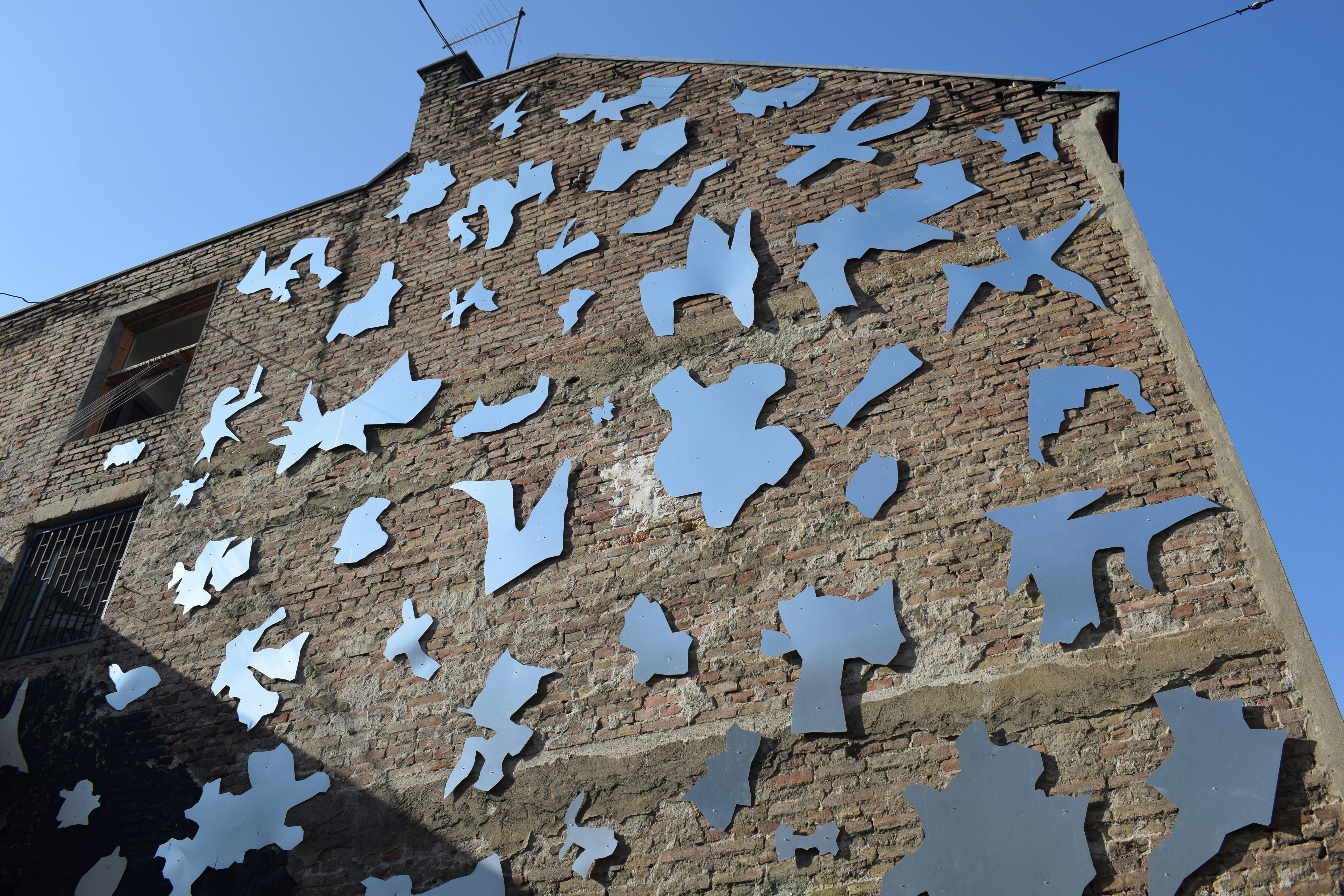 A building that has a bunch of cut outs on it photo – Free Grey Image ...