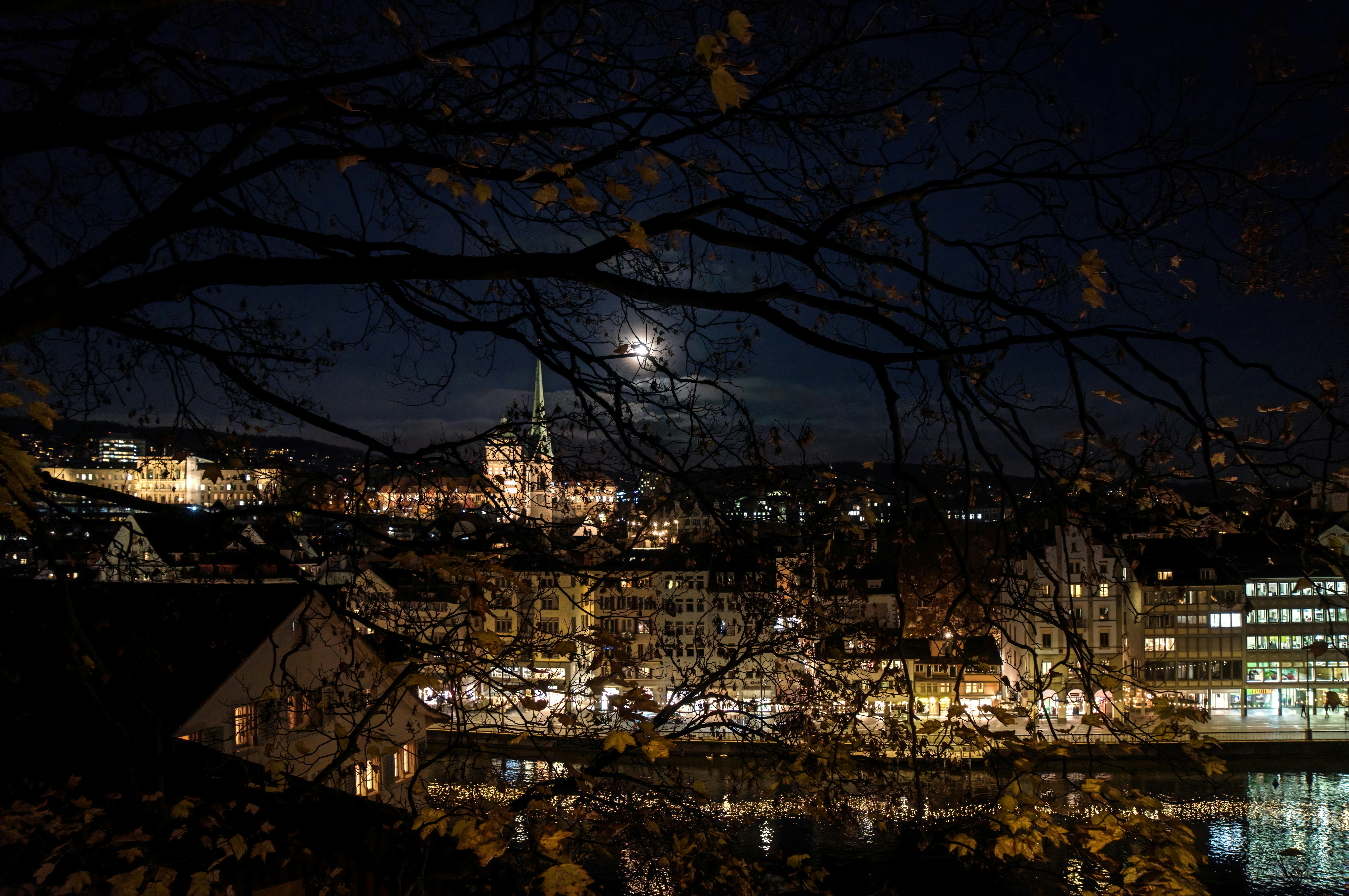 A city at night with a full moon in the sky photo – Free City Image on ...