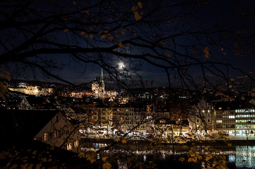 a city at night with a full moon in the sky