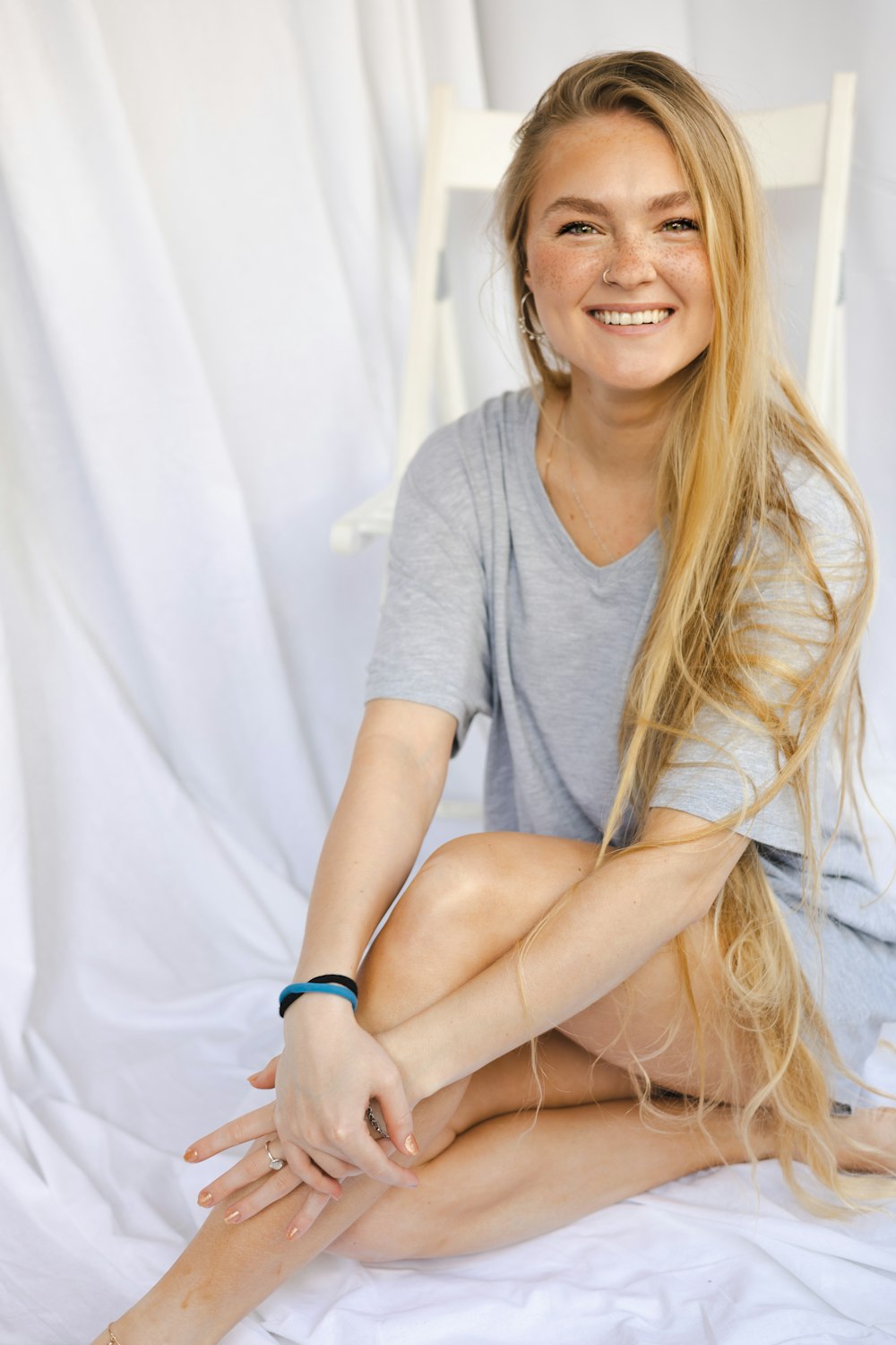 a woman sitting on a bed smiling for the camera