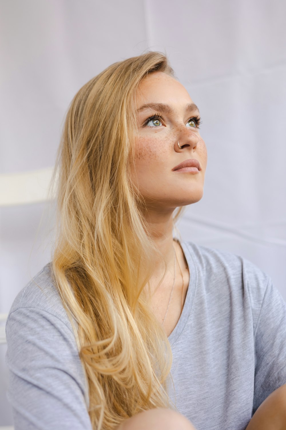a woman with long blonde hair looking up