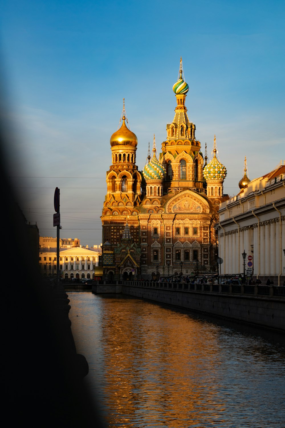 a large building with a golden dome next to a body of water