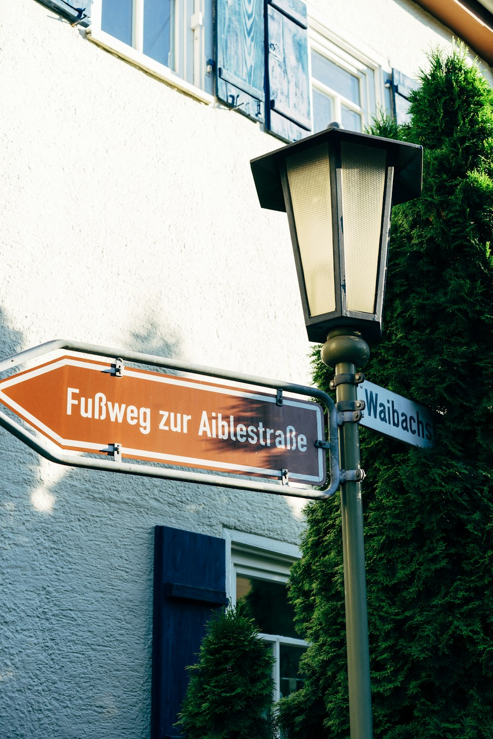 a lamp post with two street signs attached to it