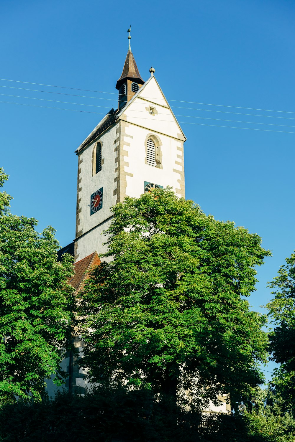 um edifício branco alto com um relógio ao lado dele