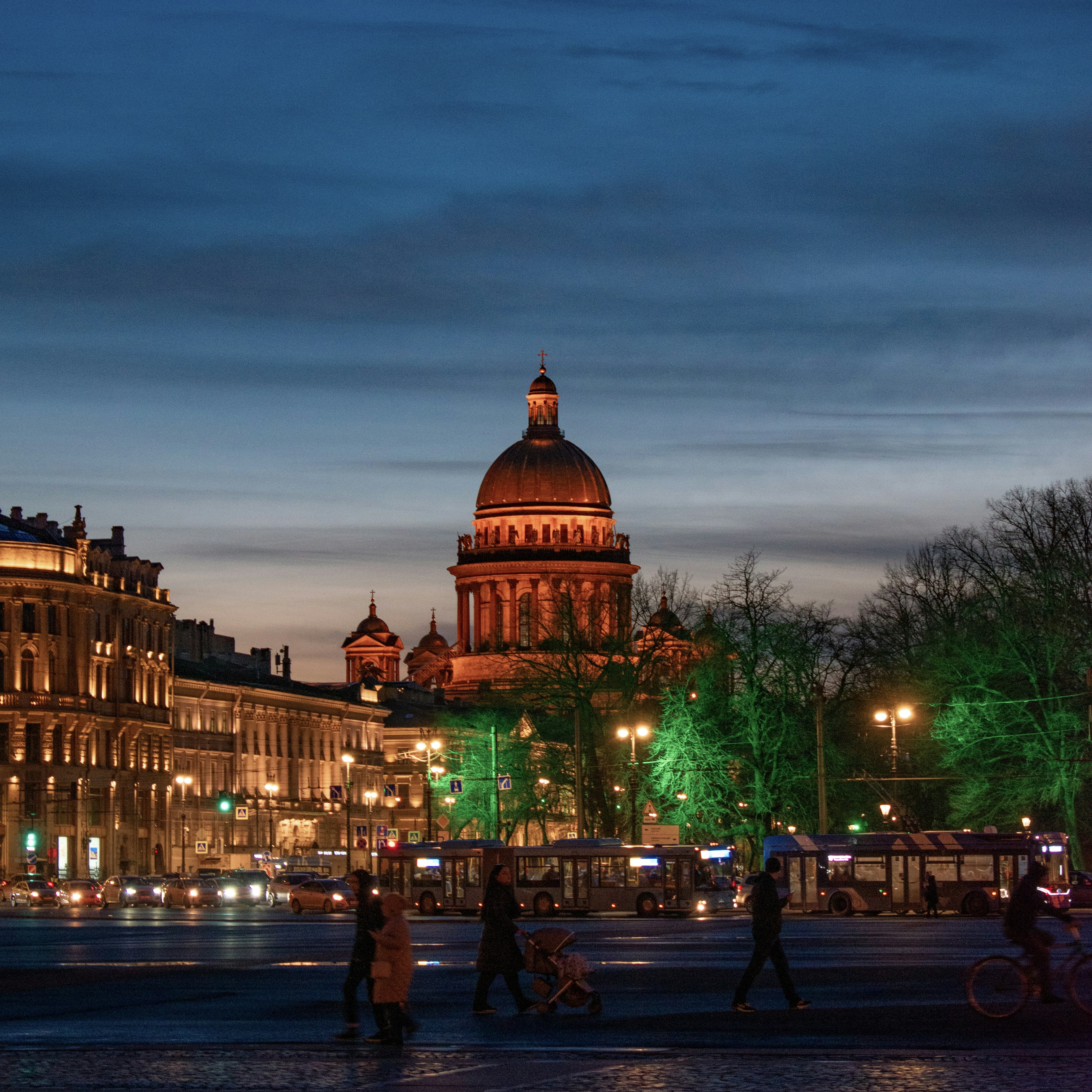 a group of people walking around a city at night