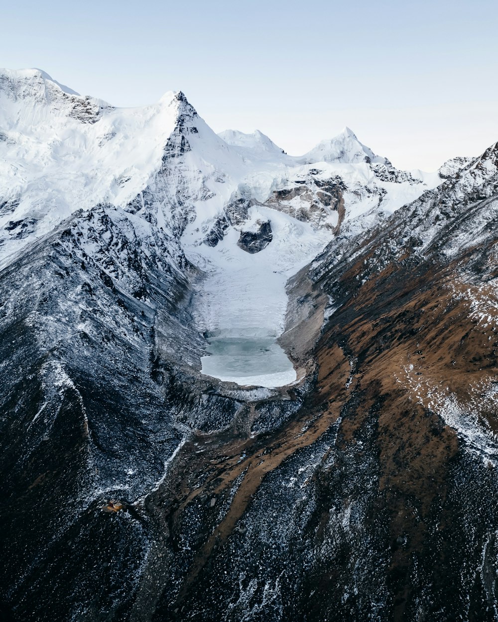 uma montanha coberta de neve com um lago no meio