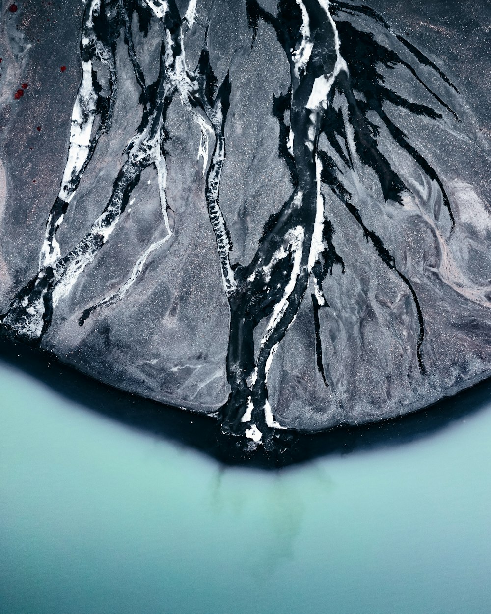 an aerial view of a mountain and a body of water