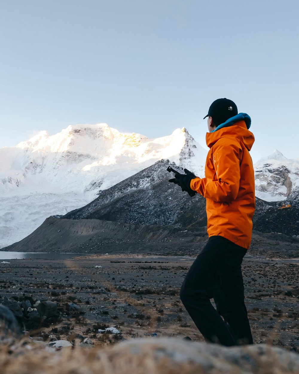 a man in an orange jacket standing in a field