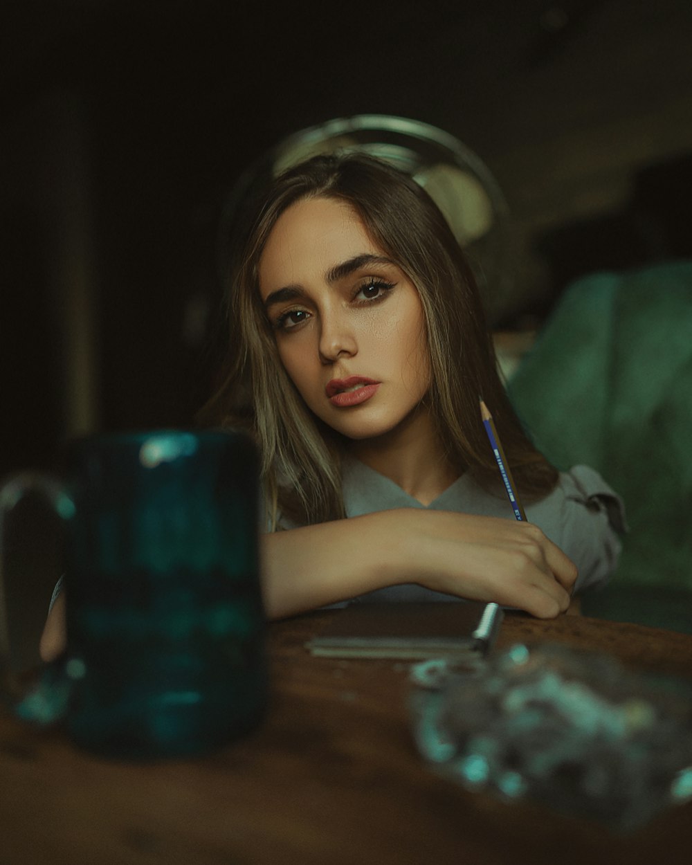 a woman sitting at a table with a pen in her hand