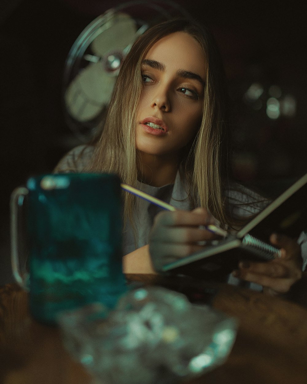 a woman sitting at a table with a book