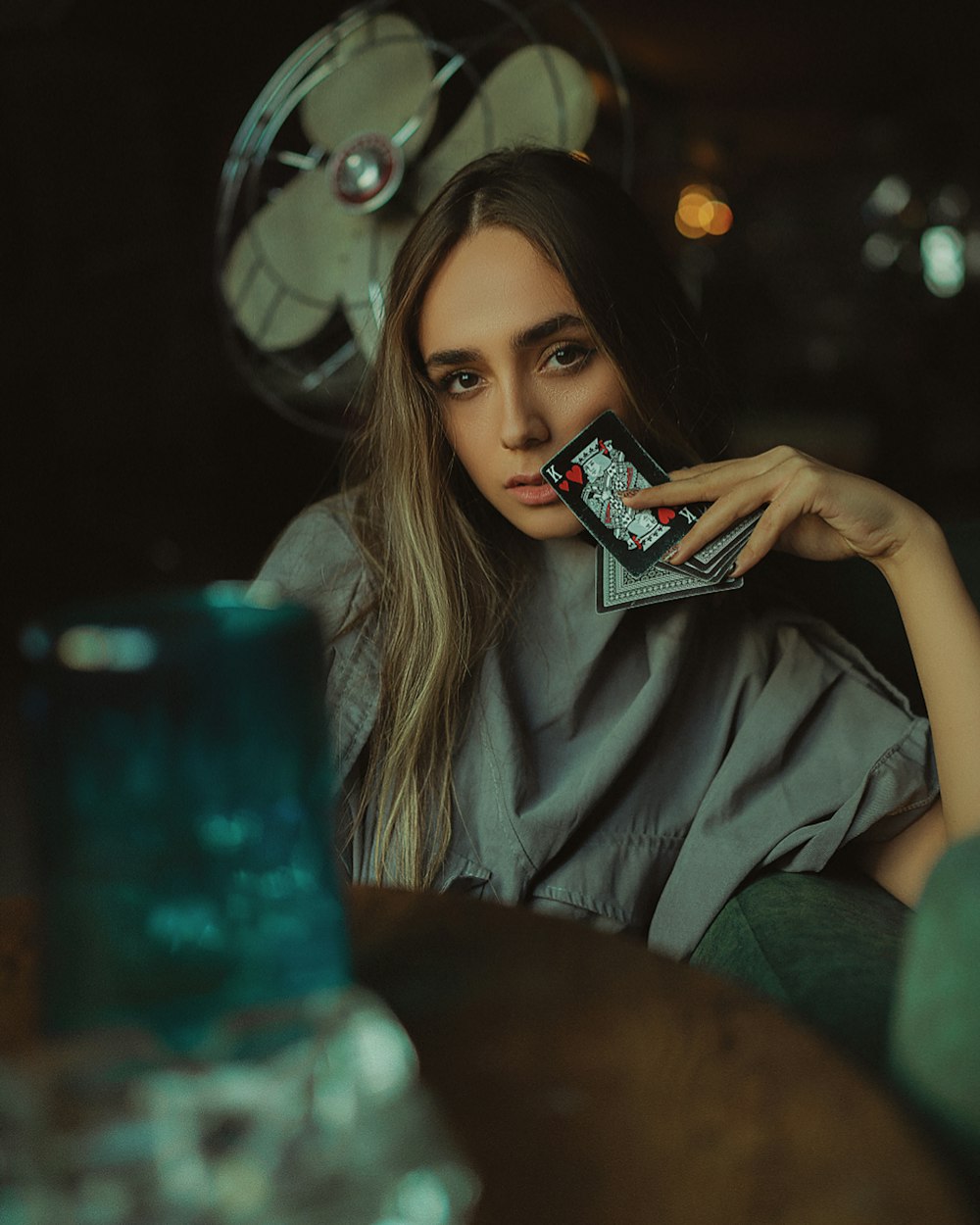 a woman sitting in a chair holding a cigarette