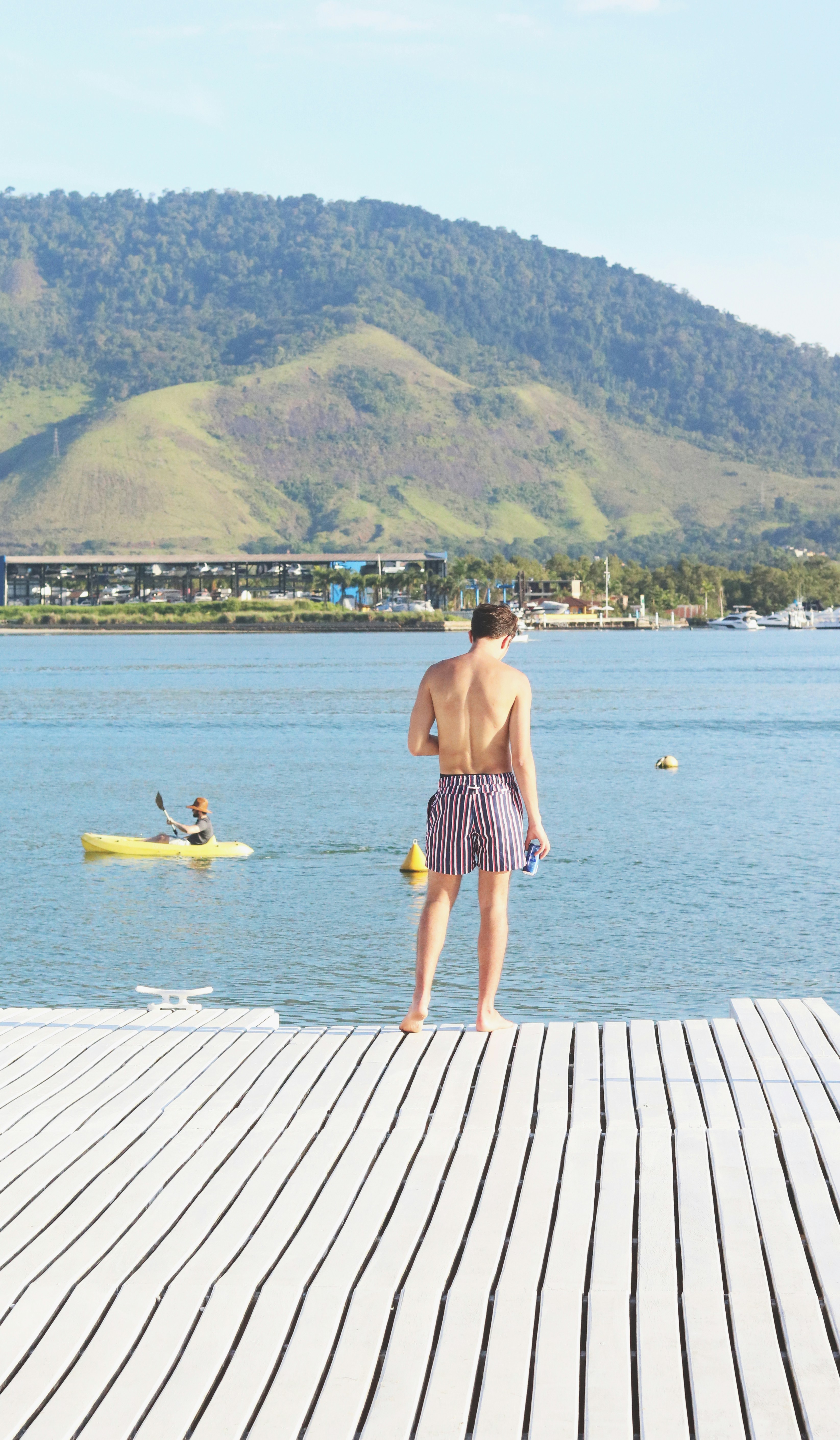a man standing on a dock next to a body of water
