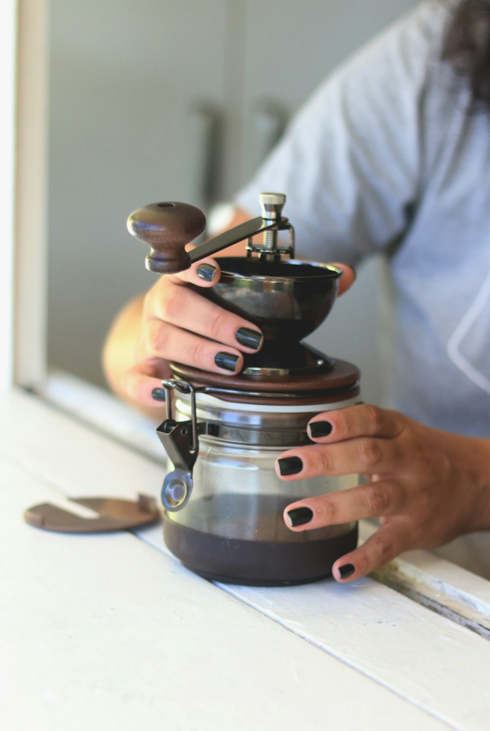 a woman holding a coffee pot on top of a counter