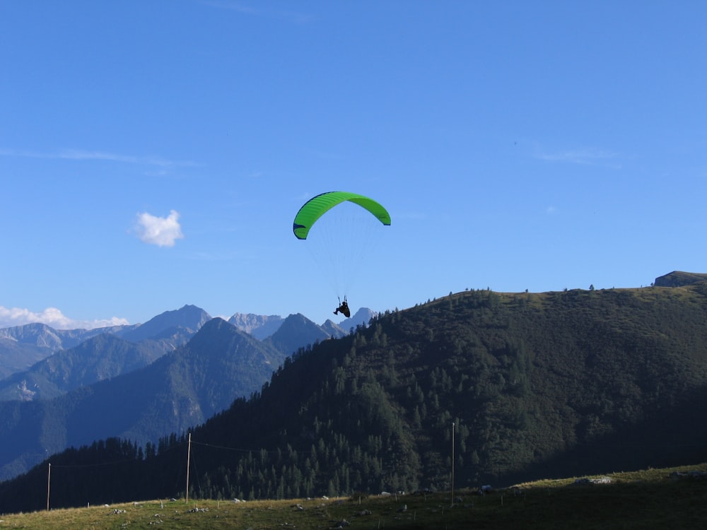 a person paragliding in the mountains on a sunny day