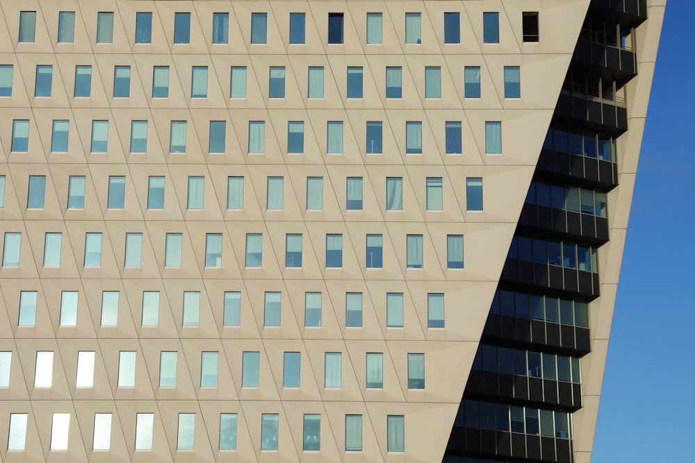 a tall building with lots of windows next to a blue sky