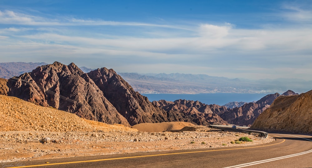 a road in the middle of a desert with mountains in the background