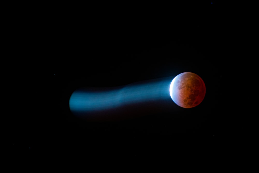 a red moon is seen in the dark sky