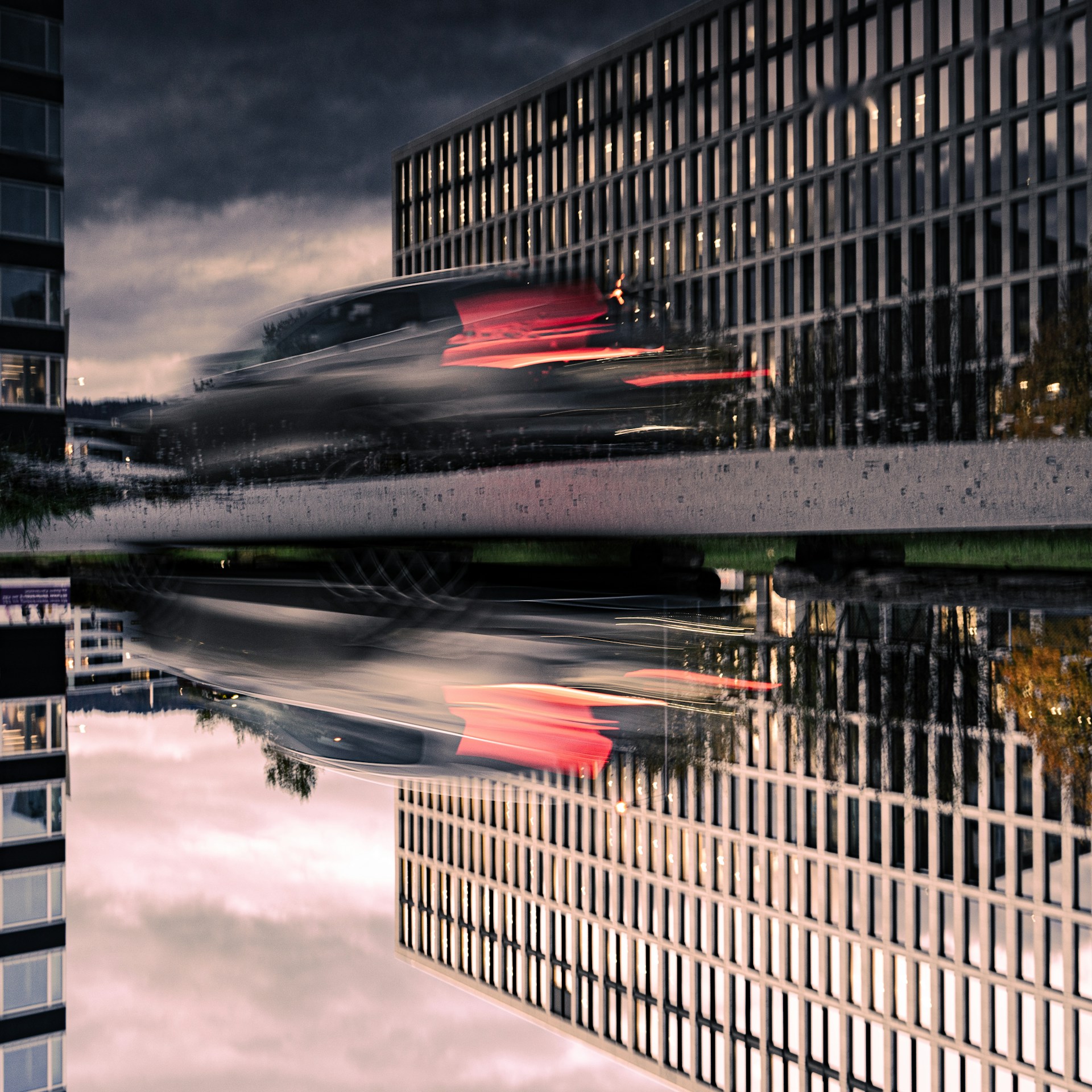 A cinematic still from a brand film showing a dynamic urban scene bathed in deep shadows and vibrant reds.