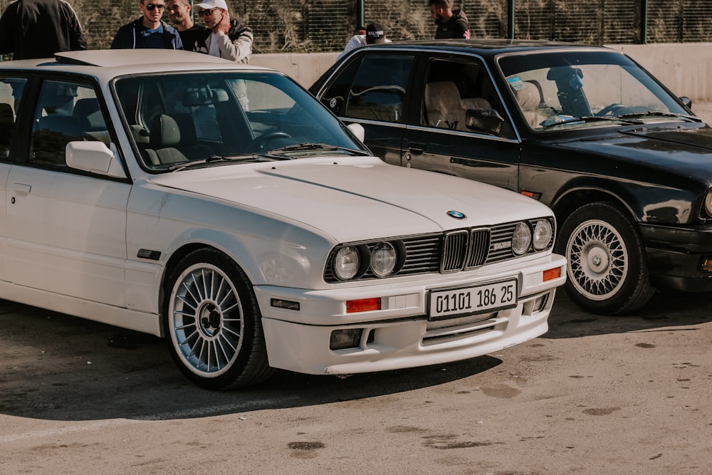 Un coche blanco aparcado junto a un coche negro