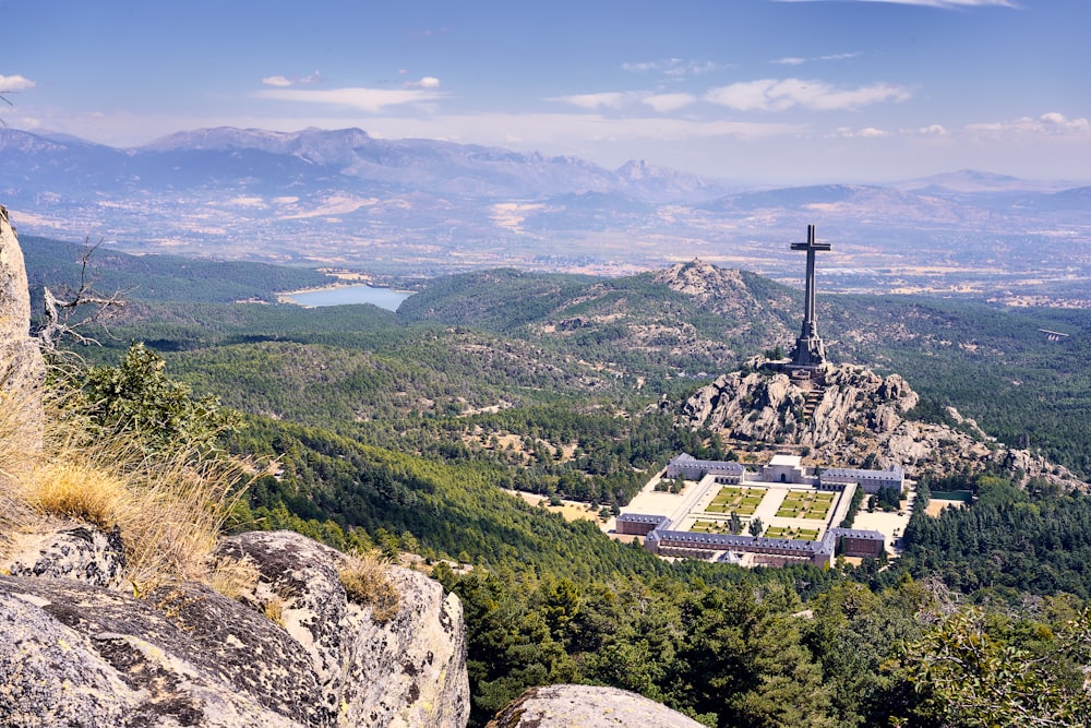 a cross on top of a mountain overlooking a valley