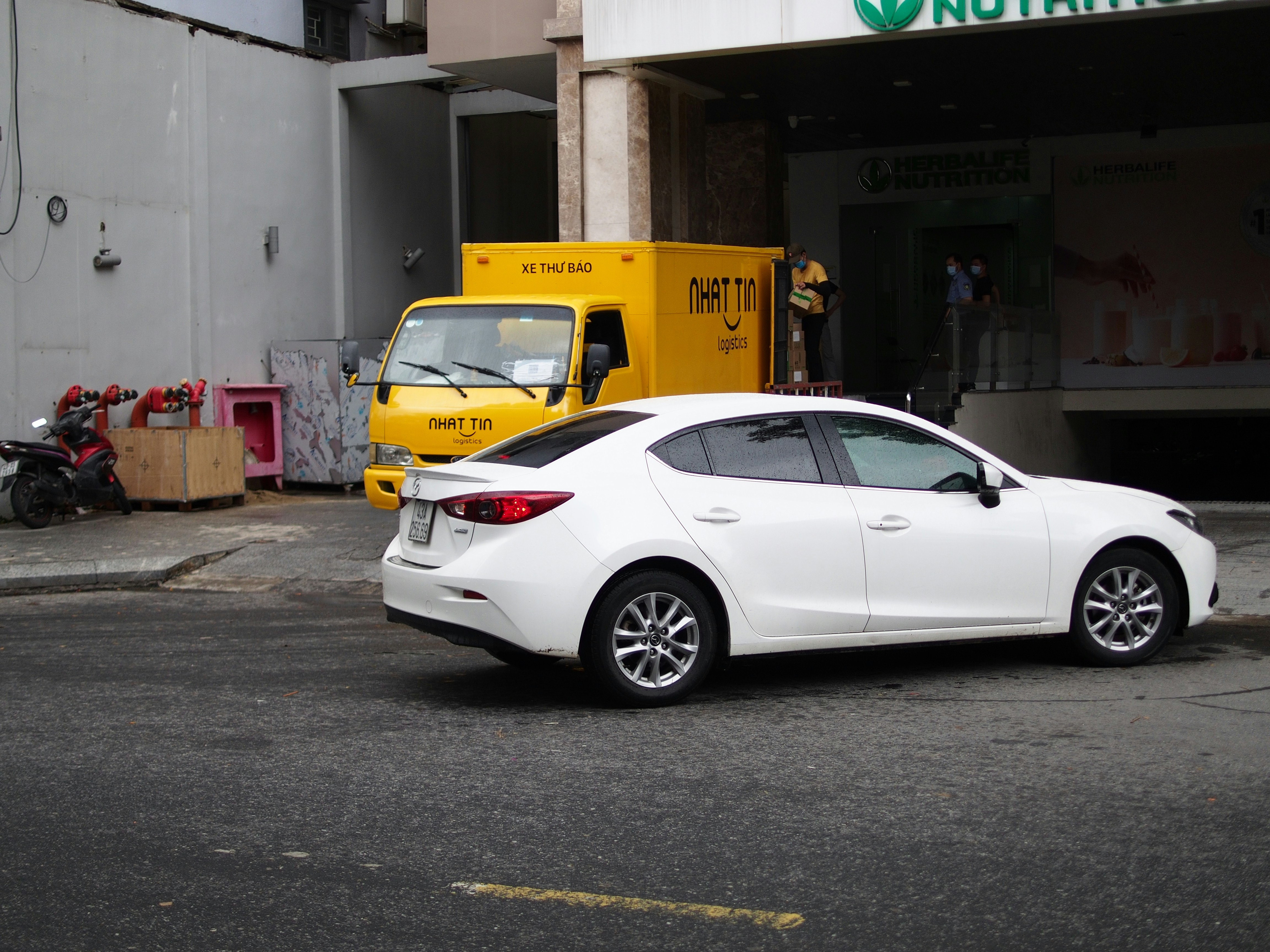 Top-down view of multiple small cars parked closely together in a city lot