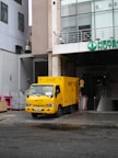 a yellow truck parked in front of a building