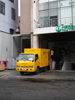 a yellow truck parked in front of a building