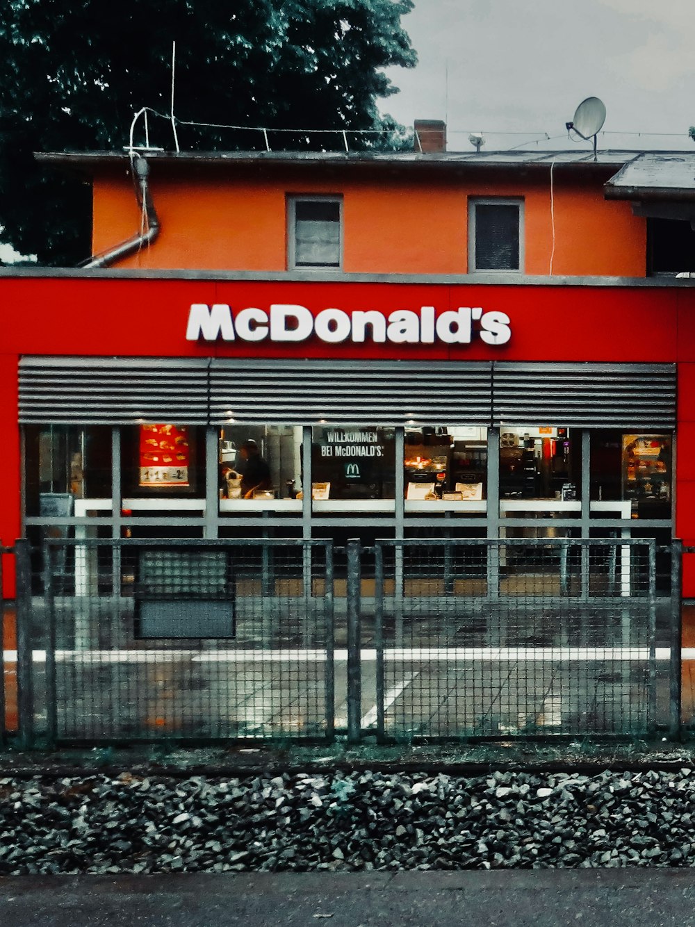 a mcdonald's restaurant with a red building behind it