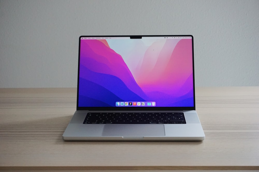 a laptop computer sitting on top of a wooden table