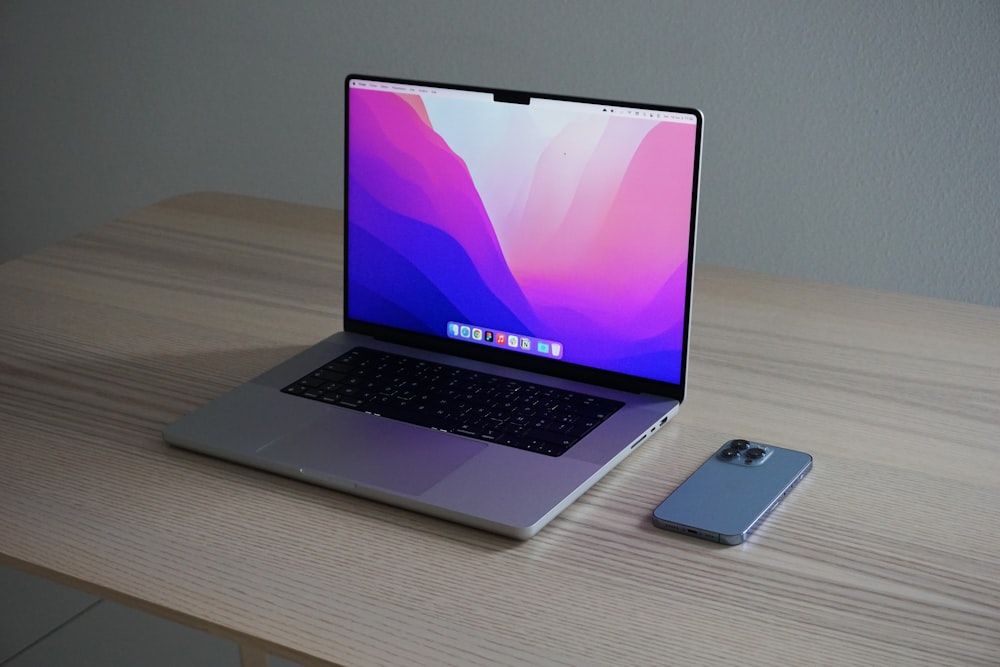 a laptop computer sitting on top of a wooden desk